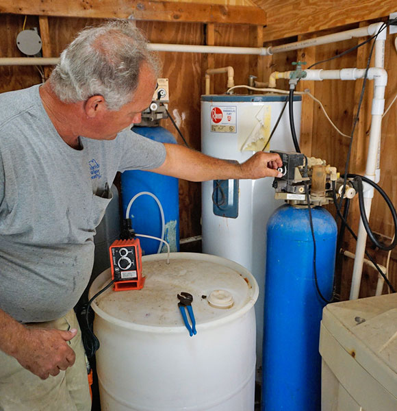 Man inspecting home water filtration and treatment system